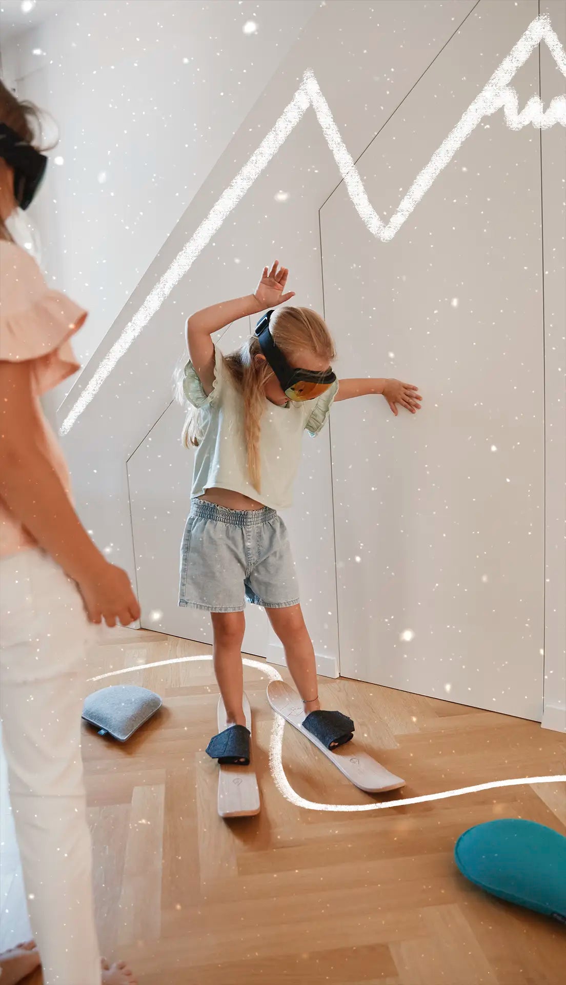 Mädchen mit Skibrille übt mit drySki Kinderskiern im Kinderzimmer – Skifahren lernen zu Hause